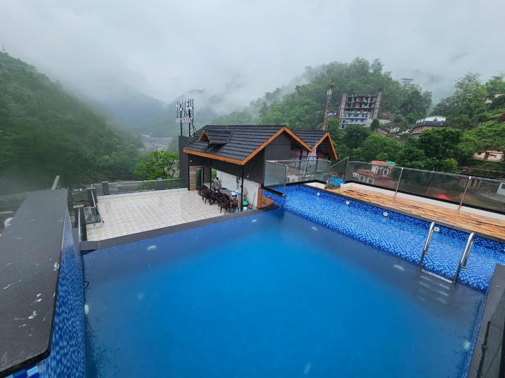 a view of a swimming pool with a house at Hotel LimeStarow in Bijni