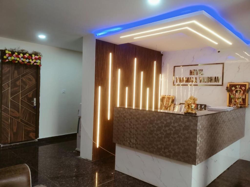 a bar in a room with a blue light at Hotel Tirumala Vaibhav in Secunderabad