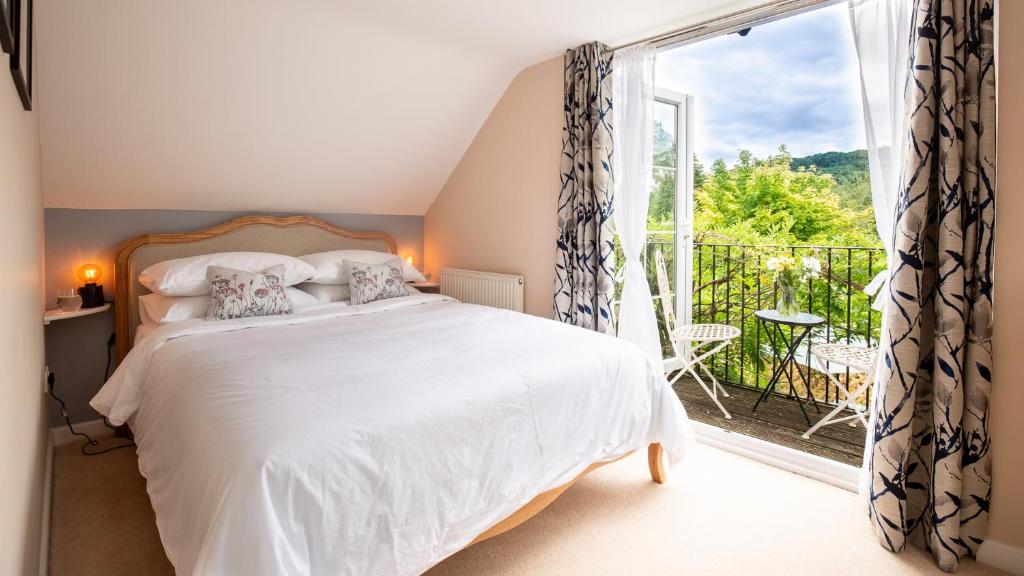 a bedroom with a bed and a large window at Lemon Tree Cottage in Broadway