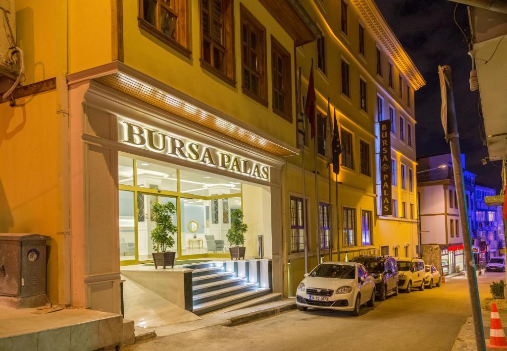 una tienda frente a un edificio con un coche aparcado fuera en Bursa Palas Hotel, en Bursa