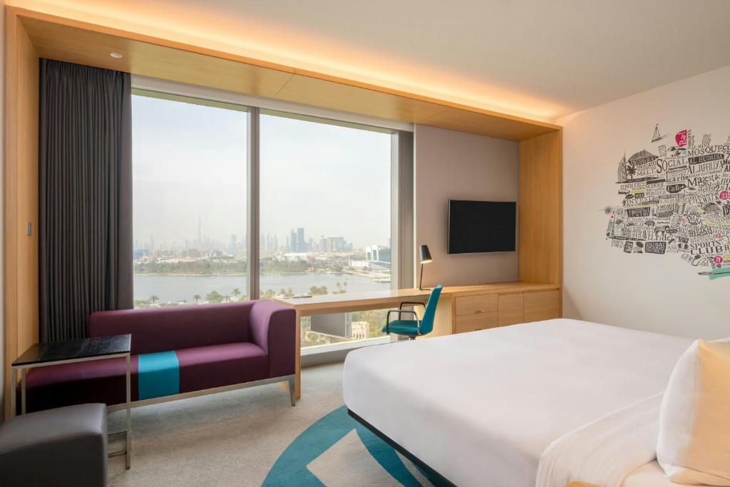 a hotel room with a bed and a window at Aloft by Marriott Dubai Creek in Dubai