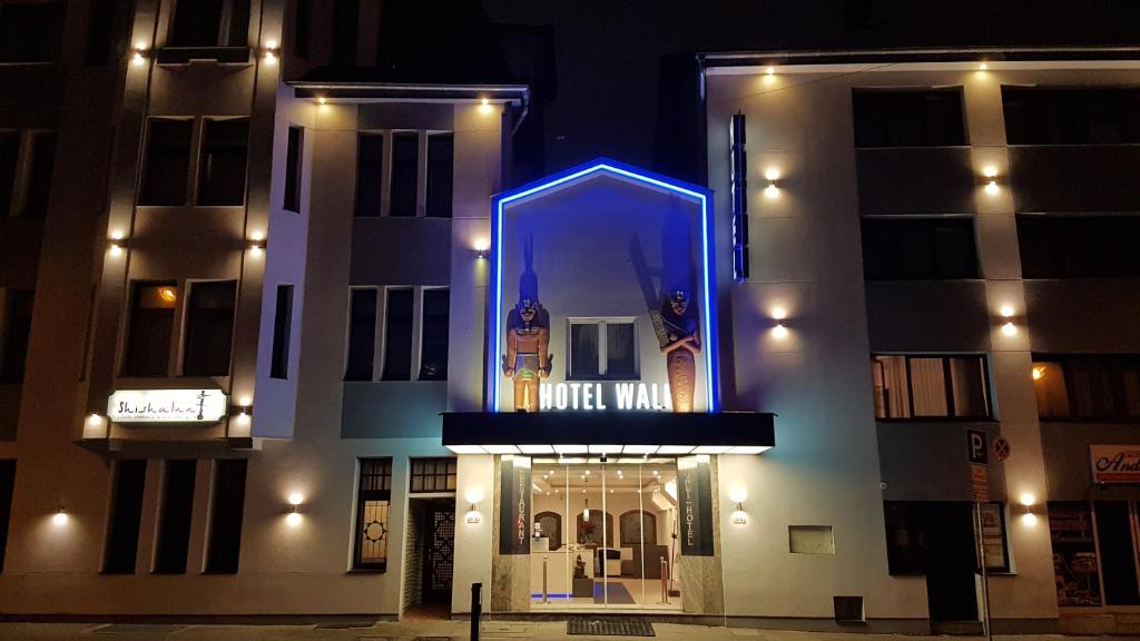 a building with a blue lit up sign on it at Wali's Hotel in Bielefeld