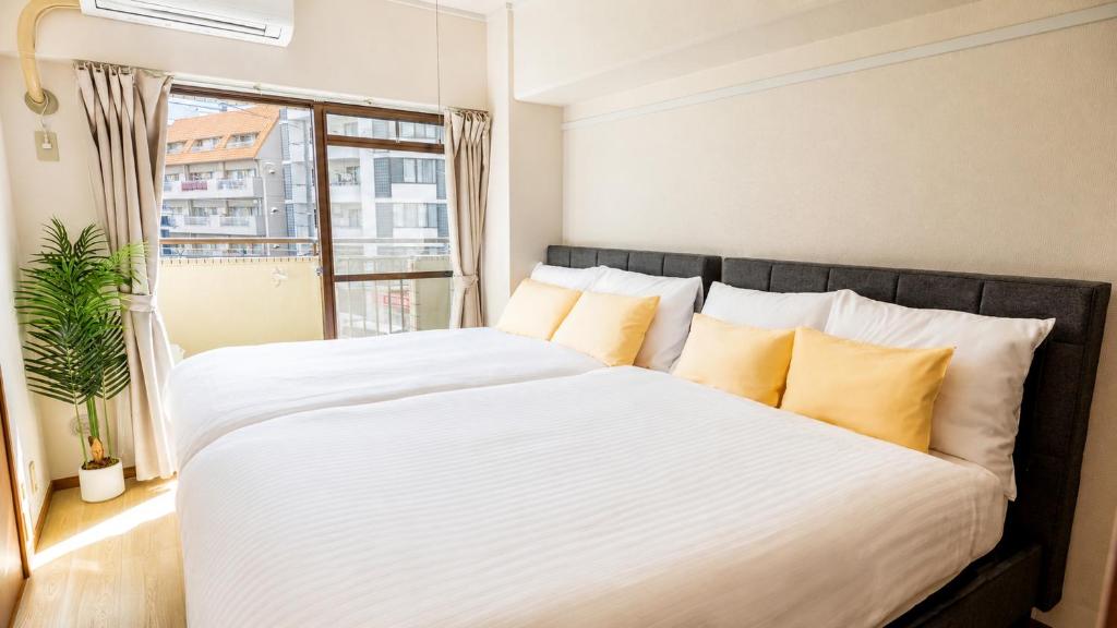 a bedroom with a large bed with yellow pillows at Roots Osaka Station 2 in Osaka