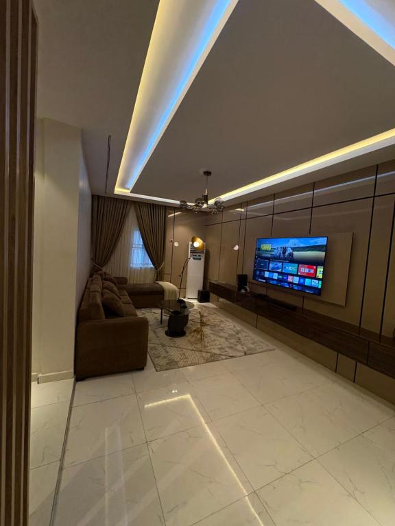 a living room with a couch and a flat screen tv at Jasabi Apartments in Port Harcourt