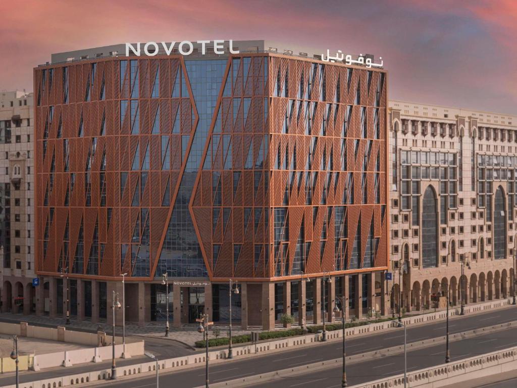 a large building with a nocet sign on top of it at Novotel Madinah in Medina