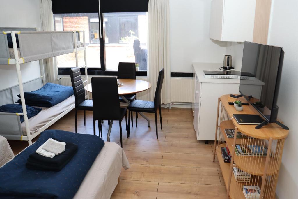 a room with a bed and a table and a kitchen at Neckelmanns BnB Room 37 in Aalborg