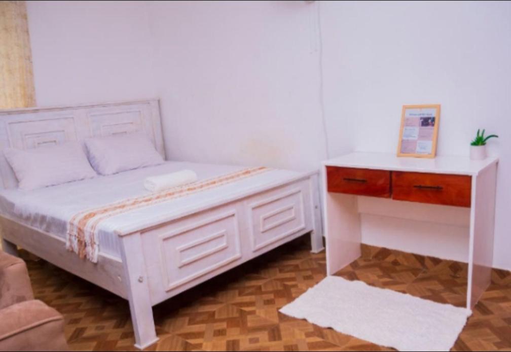 a bedroom with a white bed and a desk at MERED Haven Studio in Kilifi