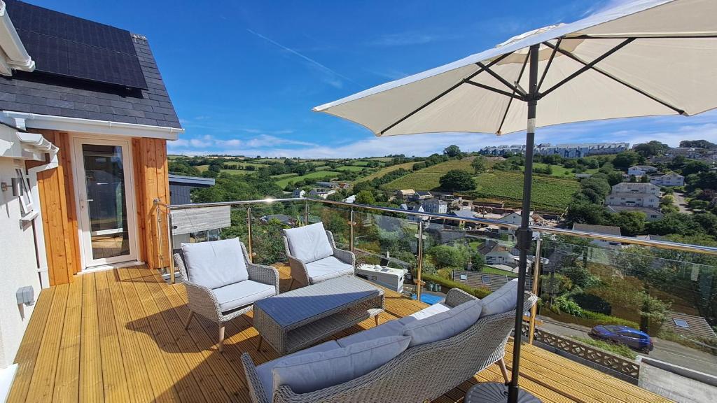 a patio with chairs and an umbrella on a deck at Valley View Haven in Kingsbridge