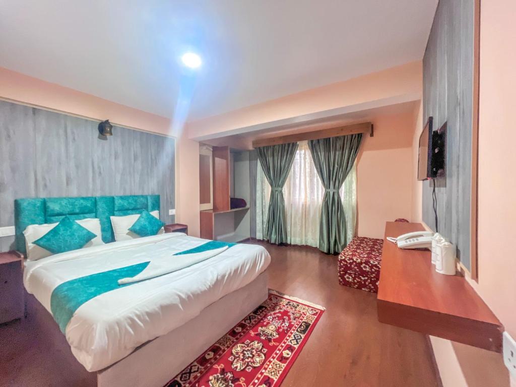 a bedroom with a large bed with a blue headboard at Rare Himalayas Mansarovar in Darjeeling