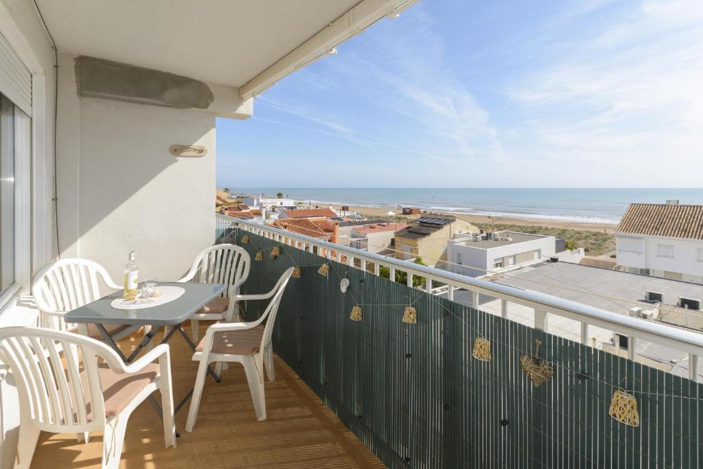 a balcony with a table and chairs and a view of the ocean at Abaco in Playa de Xeraco