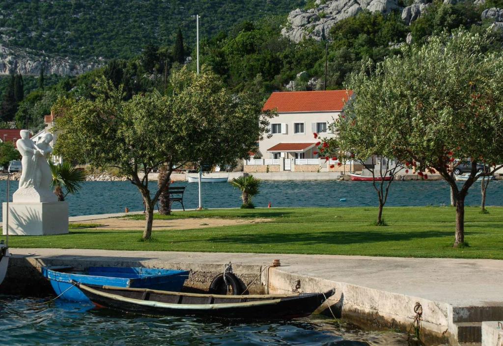 a small boat in the water next to a statue at Luxury Beachfront Villa Kata in Rogotin