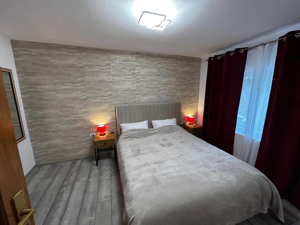 ein Schlafzimmer mit einem großen Bett und zwei Lampen auf Tischen in der Unterkunft Apart Robert 2 in Bicaz