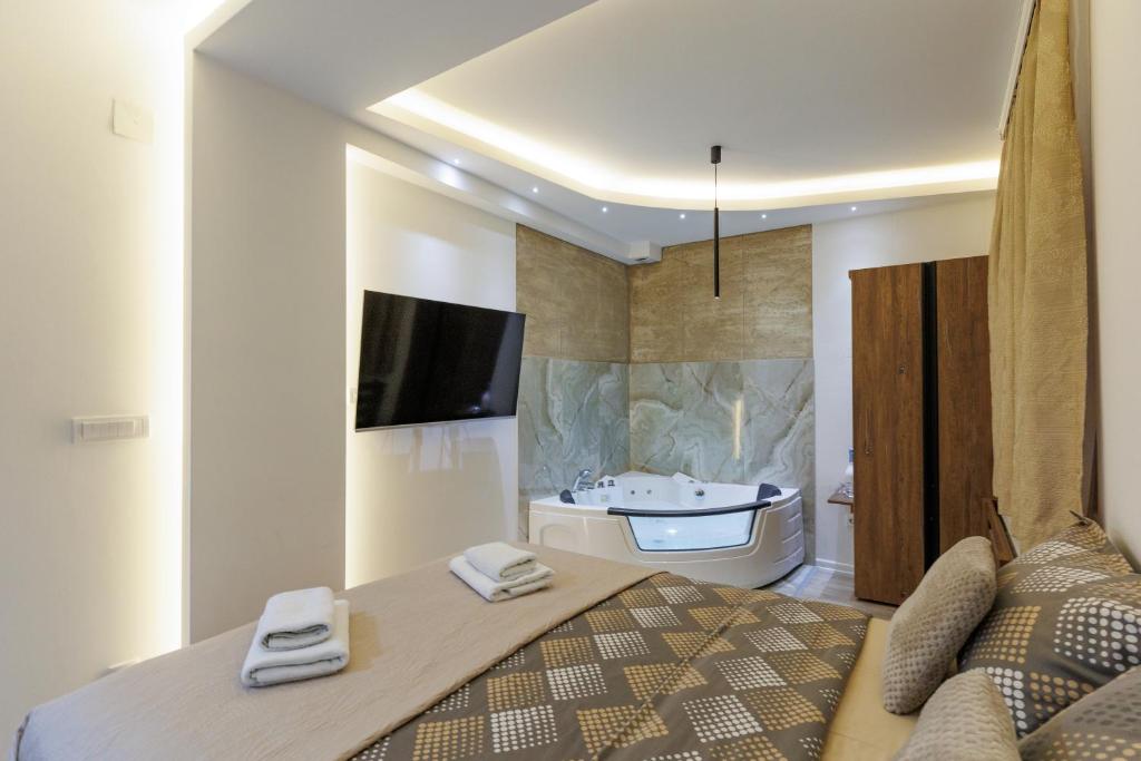 a bedroom with a bed and a bathroom with a sink at Aqua Studios with Spa & Free Parking in Jagodina