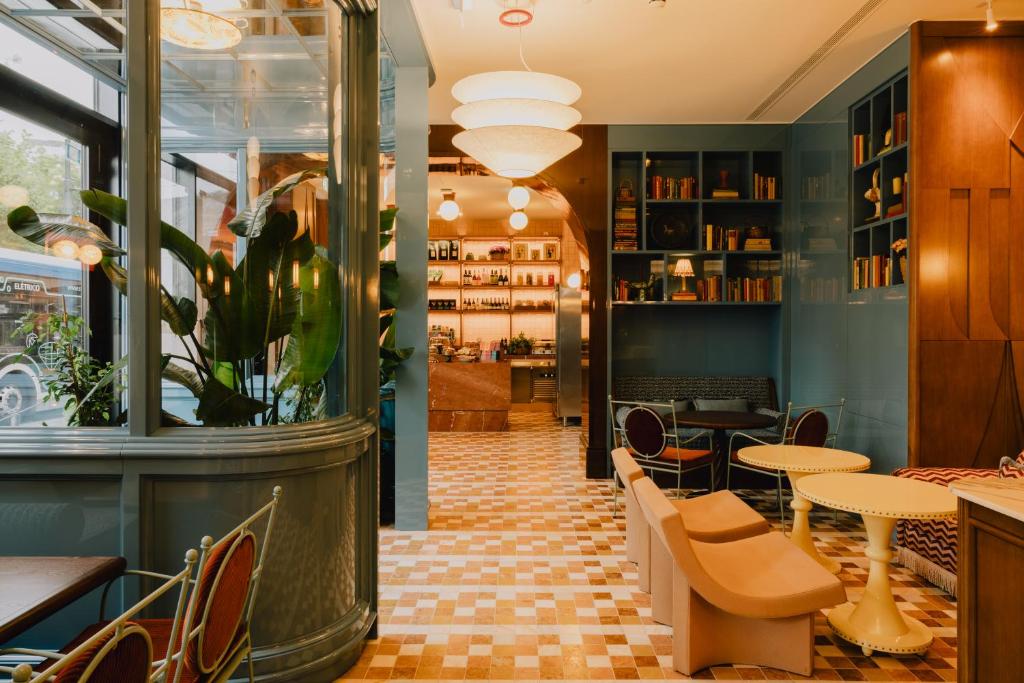 a restaurant with green walls and tables and chairs at Wilde Porto, Clerigos in Porto