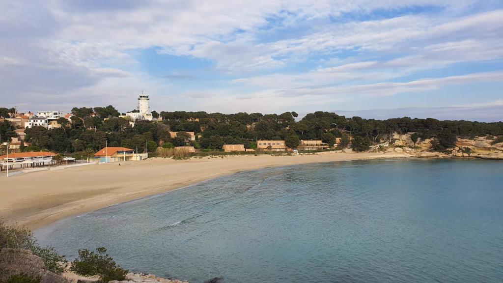 a view of a beach with a lighthouse in the distance at Villa Jamgers in Martigues
