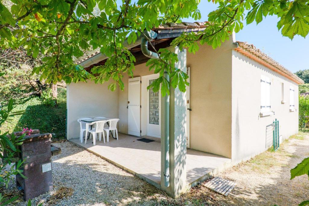 a small white house with a table and chairs at Le Cade - La Fontinelle in Bessas