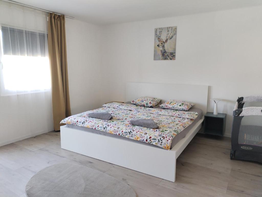 a bedroom with a bed with pillows on it at Dömper Döme Apartman 1E in Balatonlelle