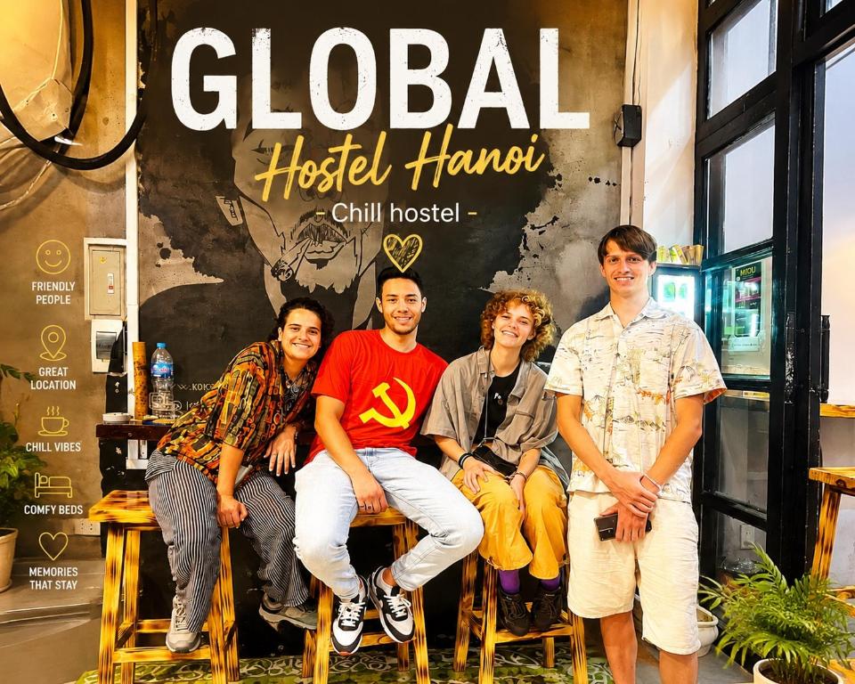 a group of people sitting in chairs in front of a store at Global Hanoi Backpackers in Hanoi