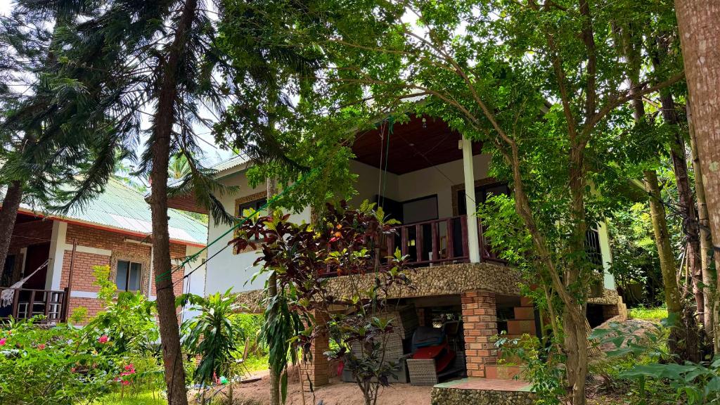 a house with a balcony in the middle of trees at Zen Trinity House in Ko Phangan