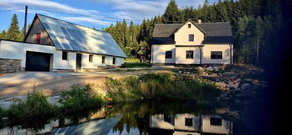 a house with a reflection in a body of water at House by the water in Lesík