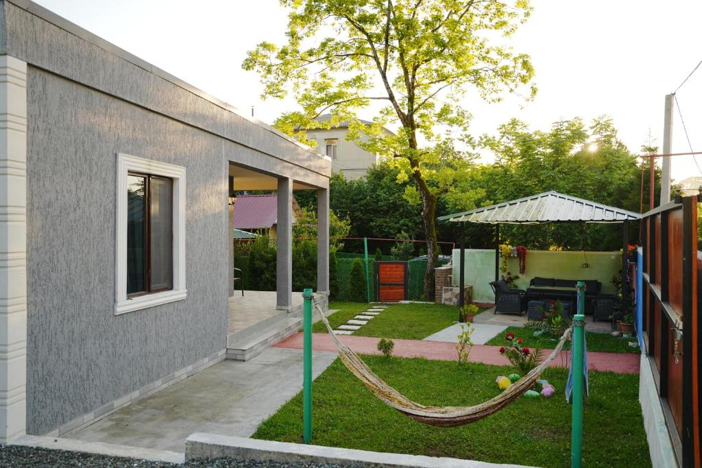 a backyard with a hammock outside of a house at sopo's cottage in Kobuleti