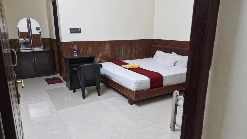 a bedroom with a bed and a table and a chair at Athirappilly Ambady Resort in Athirappilly