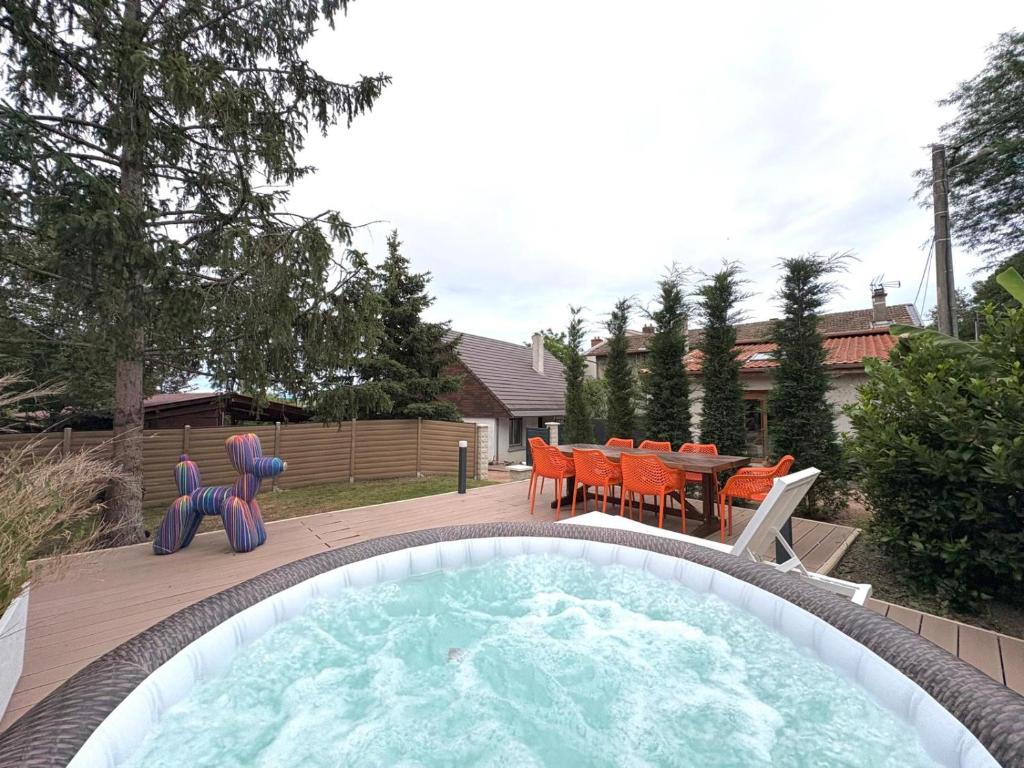 a backyard with a pool with a table and chairs at Gîte cottage & spa in Joze