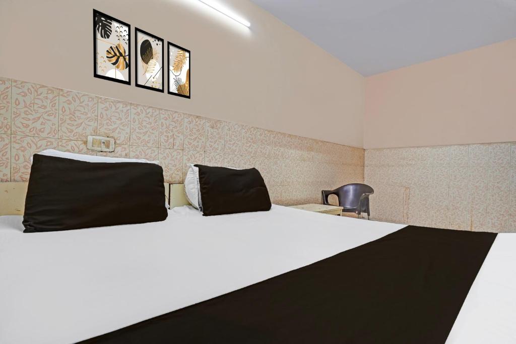 a bedroom with a large white bed and a chair at Hotel O Shivam In in New Delhi
