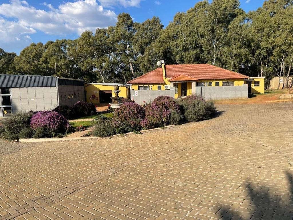 a house with a brick driveway in front of it at Cradle Mount Hotel Suites in Muldersdrift