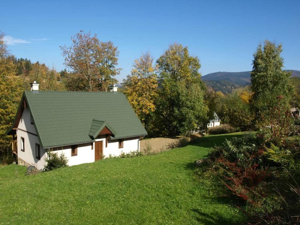 a white house with a green roof on a hill at Agroturystyka Wesoła Chmura - dom w Masywie Śnieżnika in Kletno