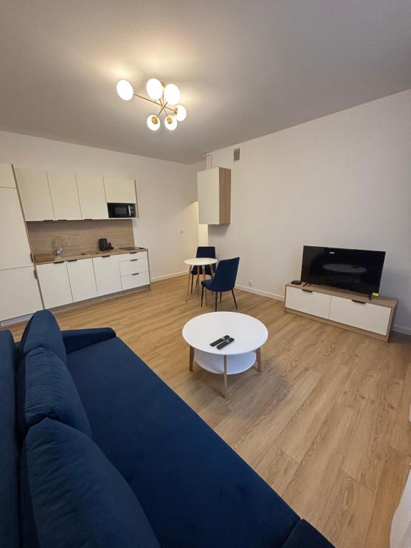 a living room with a blue couch and a table at JD Apartment Sobieskiego in Gniezno