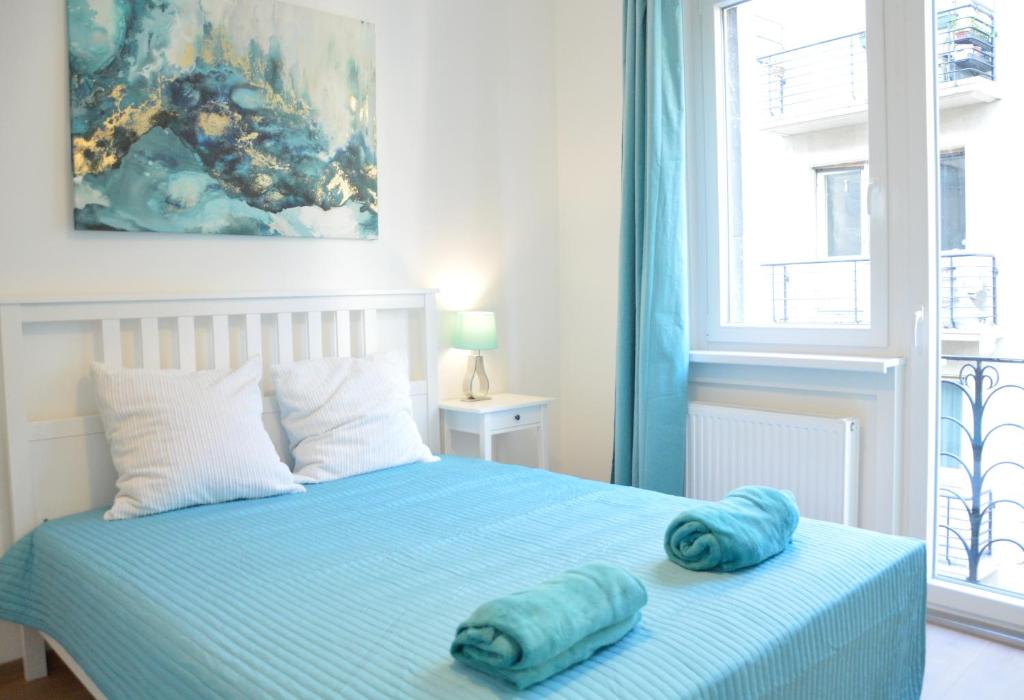ブダペストにあるTwo Bedroom Apartment at Bajcsyのベッドルーム1室(青いシーツと窓付)