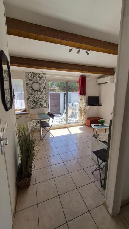 a living room with a tile floor and a large window at Les Cigalines très proche village natu in Cap d'Agde
