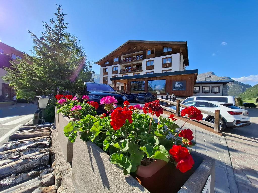 a group of flowers inpots in front of a building at Hotel Bernina in Livigno