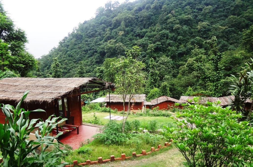 eine Gruppe von Gebäuden vor einem Berg in der Unterkunft Rishikesh Valley in Rishikesh
