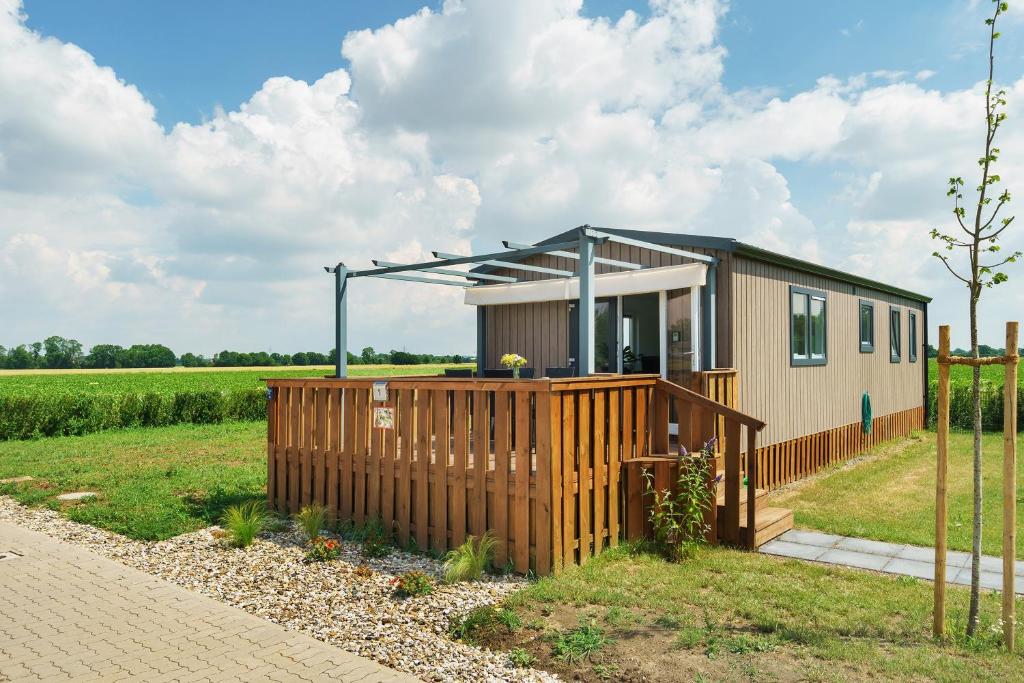 a tiny house in a field with a fence at Rotkäppchen in Dörverden