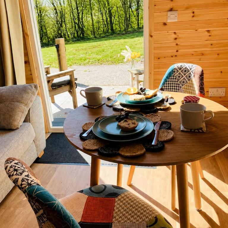 a table with food on it in a living room at Kestrel Cabin Quiet Woodland Cabin & Nature in Eyam