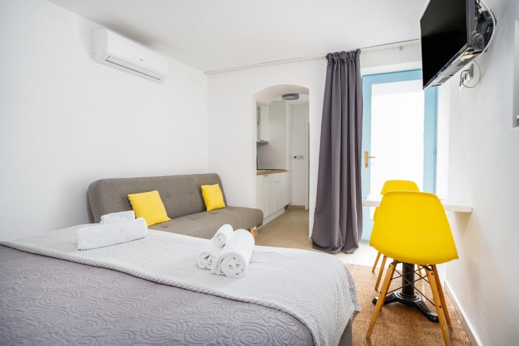a bedroom with a bed and a yellow chair at Hvar Villa Maris in Hvar