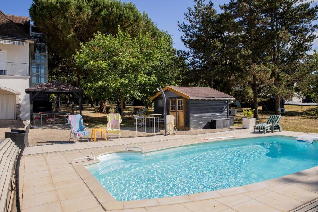 a swimming pool with a house and a shed at Clos Sainte Anne avec piscine in Cour-Cheverny