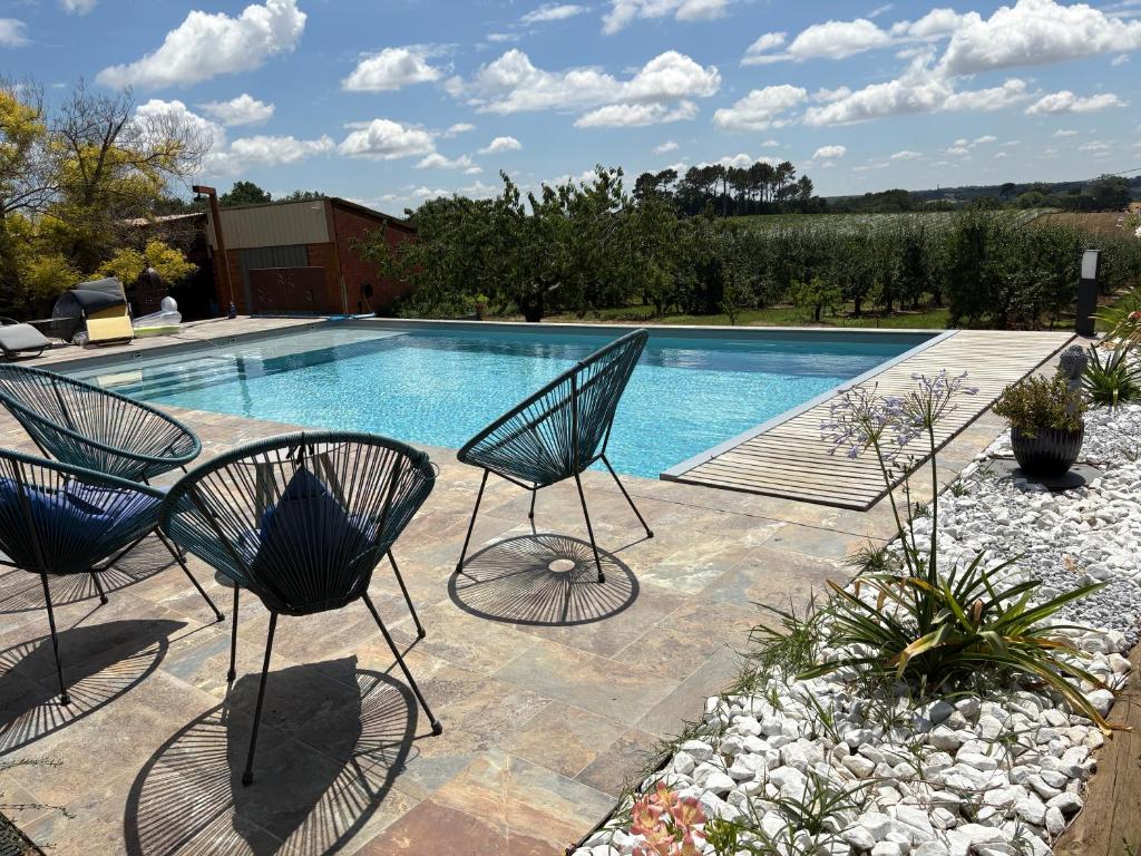 a pool with two chairs and a swimming pool at Les vergers d'Anjoy in Montesquieu