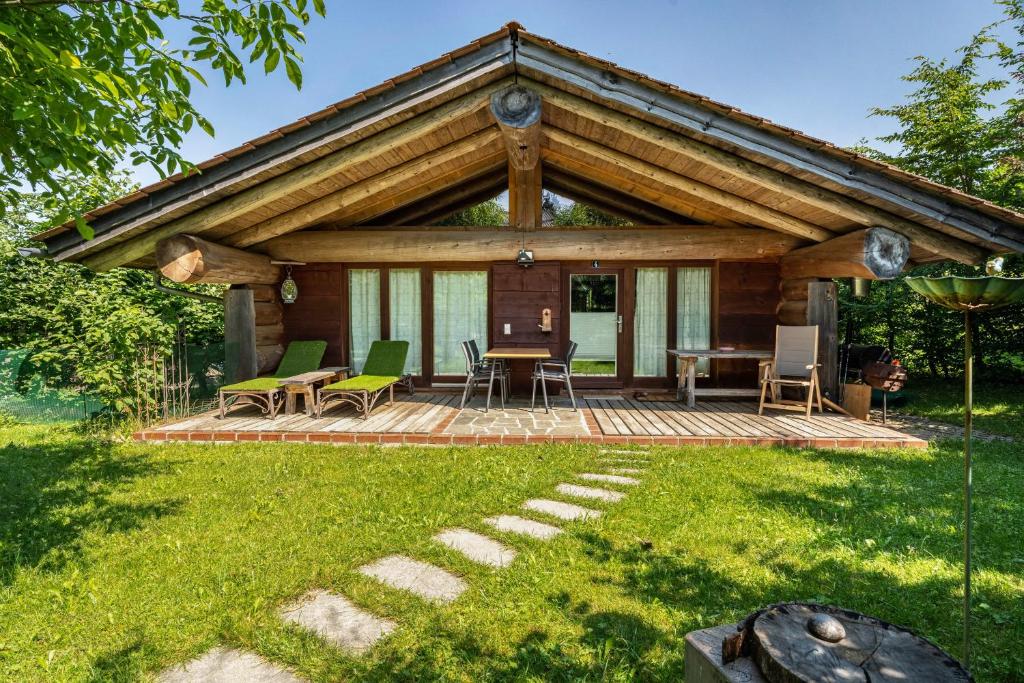 a cabin with a deck with a table and chairs at Chalet 4 in Sankt Englmar