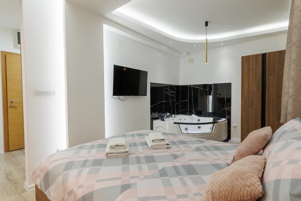 a bedroom with a large bed and a bath tub at Aqua Apartments 1 in Jagodina
