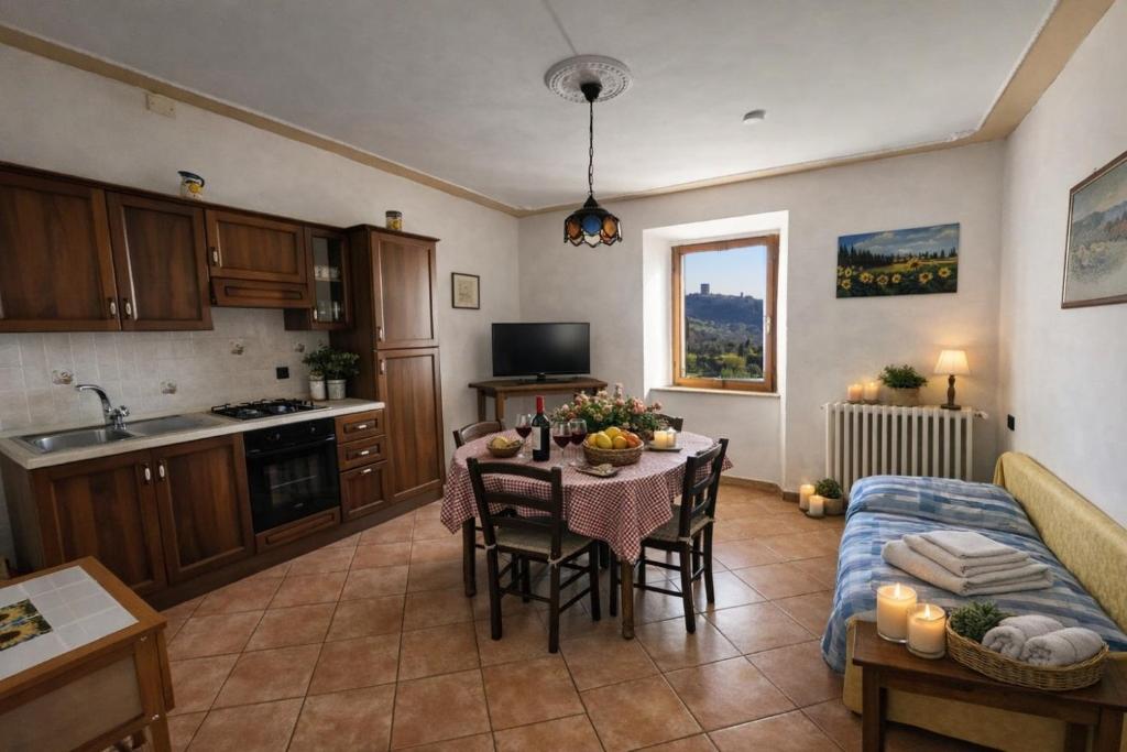 a kitchen and living room with a table and a couch at I Castagnini in Montecatini Val di Cecina