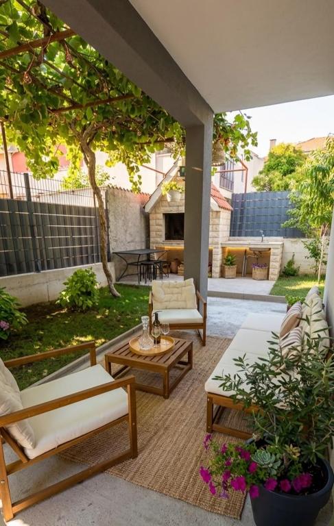 a patio with couches and chairs and a table at Rina Apartment- with barbecue and free parking in Kaštela