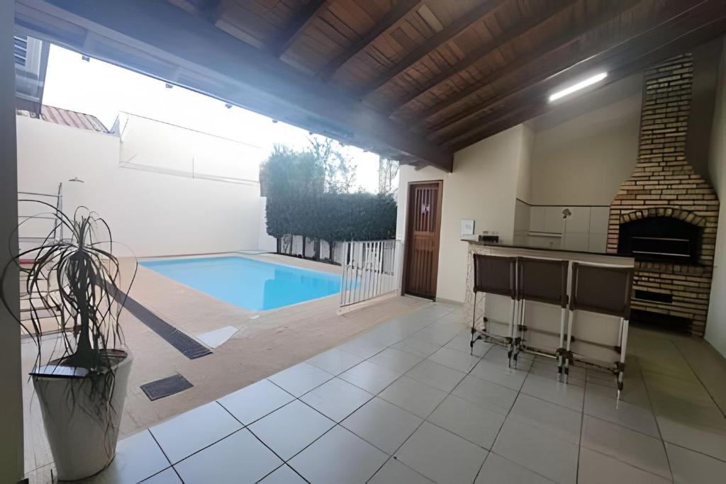 a large kitchen with a pool and a fireplace at Campo Grande Guest Flat in Campo Grande