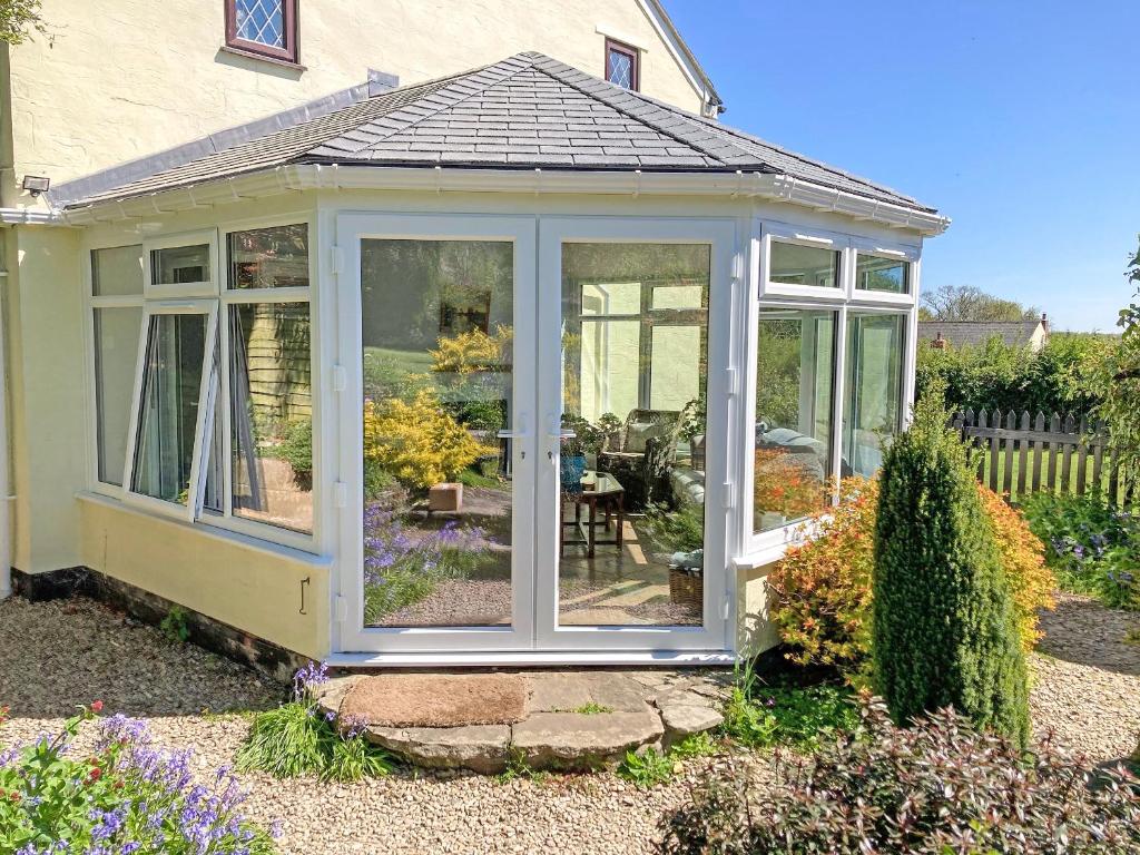 a conservatory with glass doors in a garden at Oak Tree Cottage - E5062 in Birley