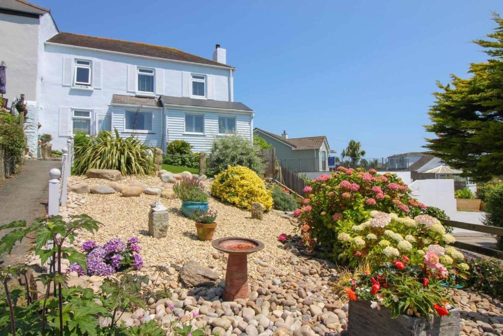 a garden in front of a house with flowers at Summers Beach View in Saint Mawes