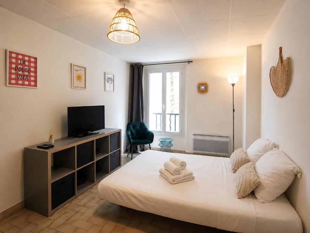 a bedroom with a bed with a television and a desk at Studio centre-ville avec ascenseur - Le Mistral in Digne-les-Bains