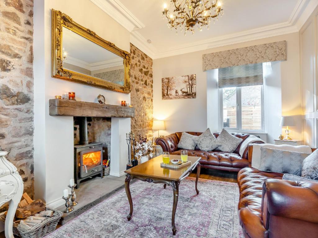 a living room with a couch and a fireplace at West House in Wooler