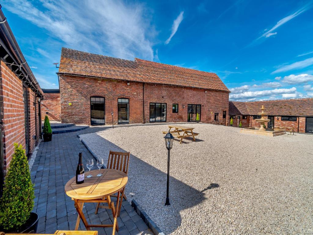 a patio with a table and a bottle of wine at Stable View Barn - Uk45938 in Corley